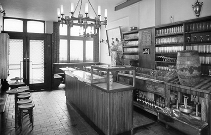 Ein historisches Apothekeninterieur mit zahlreichen Flaschen und Kräuterbehältern.